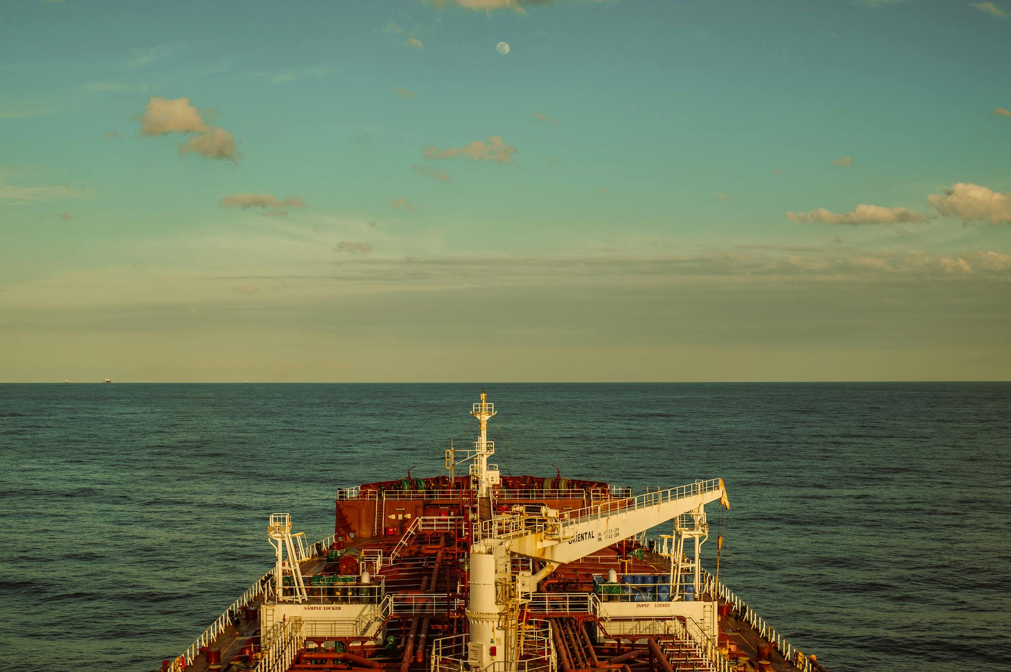 A large cargo ship navigates through calm seas under a clear sky, highlighting maritime transport.