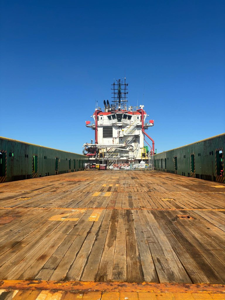 View of a cargo ship's deck under a clear blue sky in Brazil, showcasing maritime industry.